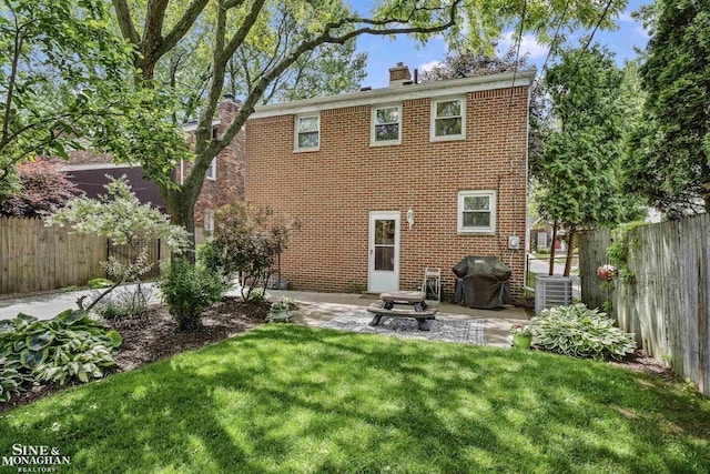 1984 Lancaster St, Grosse Pointe Woods, MI 48236 - rear view of house featuring a chimney, a patio, central AC unit, and brick siding