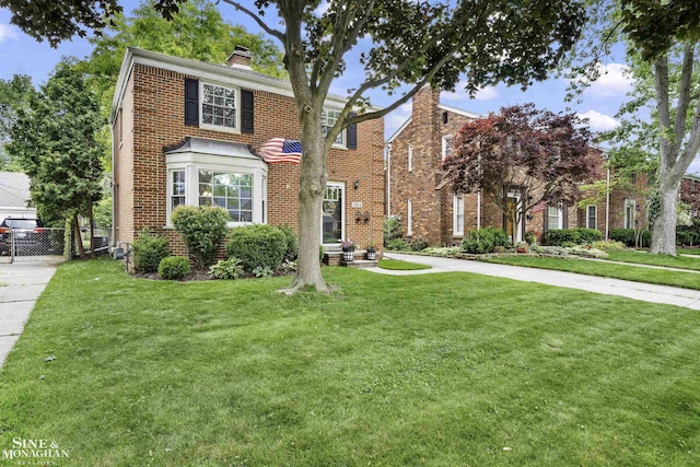 1984 Lancaster St, Grosse Pointe Woods, MI 48236 - view of front of property featuring a front yard, a chimney, and brick siding