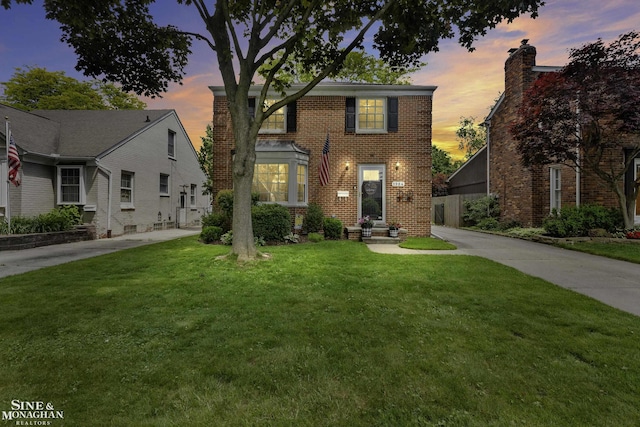 1984 Lancaster St, Grosse Pointe Woods, MI 48236 - view of front of home with a front yard, brick siding, and a chimney