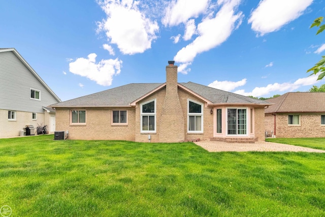 52225 Bryan Michael Dr, Macomb, MI 48042 - rear view of property featuring a chimney, brick siding, and a yard