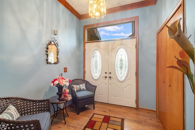 52225 Bryan Michael Dr, Macomb, MI 48042 - entryway featuring a chandelier, ornamental molding, and light wood-style flooring