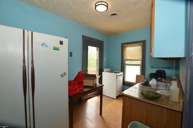 17530 Oakdale St, Roseville, MI 48066 - kitchen with white appliances, light wood-style flooring, and a textured ceiling