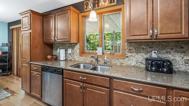 533 25th St, Gladstone, MI 49837 - kitchen featuring dishwasher, brown cabinets, dark stone counters, backsplash, and light wood-type flooring