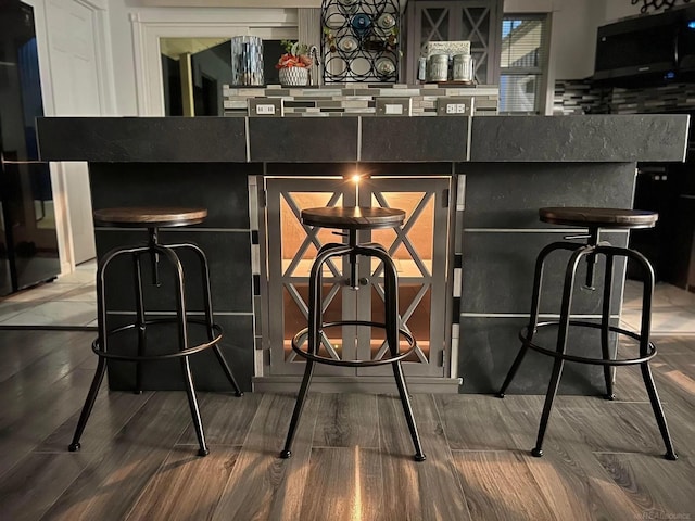 1335 28th St, Manistee, MI 49660 - detailed view of wood finished floors, black microwave, and decorative backsplash