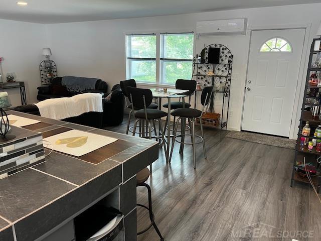 1335 28th St, Manistee, MI 49660 - dining room featuring a wall mounted AC and wood finished floors