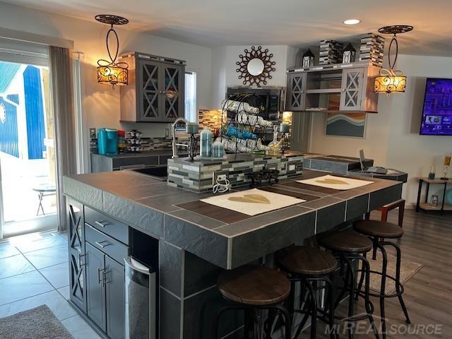 1335 28th St, Manistee, MI 49660 - kitchen with a kitchen bar, dark countertops, and pendant lighting