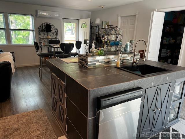 1335 28th St, Manistee, MI 49660 - kitchen featuring dishwasher, tile countertops, healthy amount of natural light, and wood finished floors