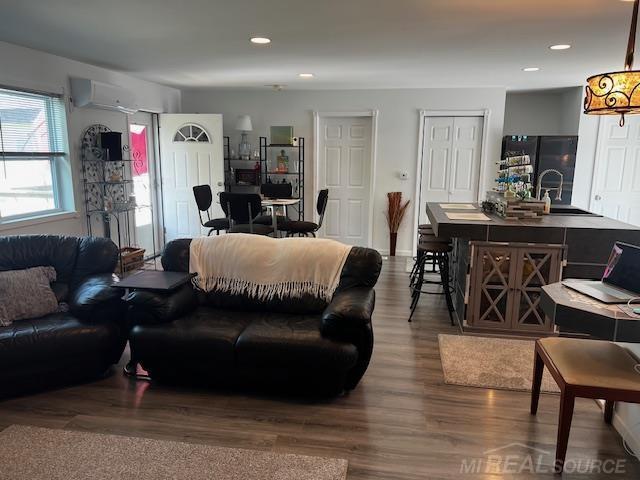 1335 28th St, Manistee, MI 49660 - living area featuring a wall mounted air conditioner, dark wood finished floors, and recessed lighting