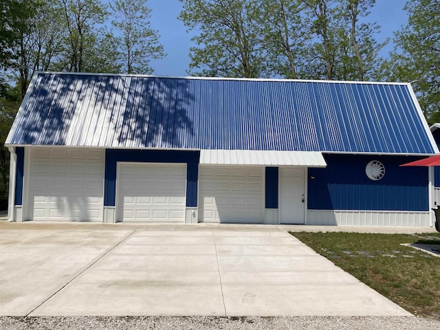 1335 28th St, Manistee, MI 49660 - view of front facade featuring a metal roof, a garage, and driveway