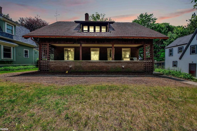1200 Wells St, Ann Arbor, MI 48104 - view of front of home with brick siding, a front yard, covered porch, and a chimney