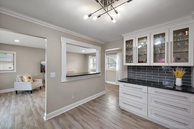 37738 Maplehill St, Harrison Twp, MI 48045 - kitchen featuring crown molding, light wood-type flooring, glass insert cabinets, decorative backsplash, and a chandelier