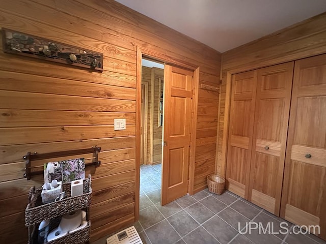 21988 E Everett Ave, Grand Marais, MI 49839 - hall with wood walls and dark tile patterned floors