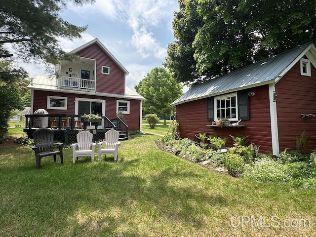 21988 E Everett Ave, Grand Marais, MI 49839 - back of house with a balcony, a yard, a metal roof, and an outbuilding
