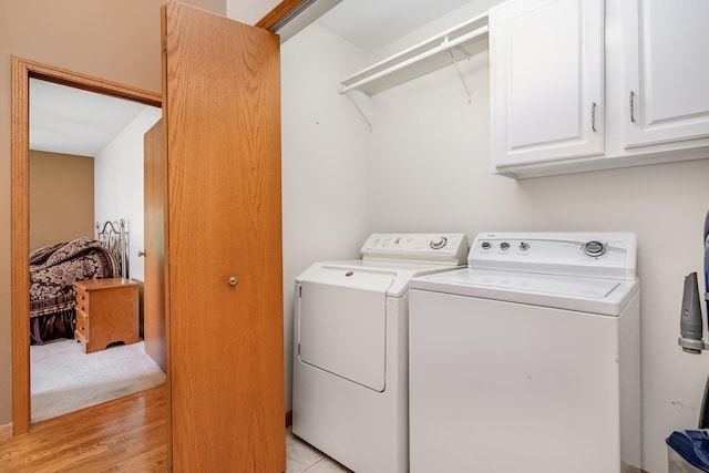 810 Natures Ridge Ln, Bay City, MI 48708 - washroom with cabinet space, washing machine and dryer, and light wood-style flooring