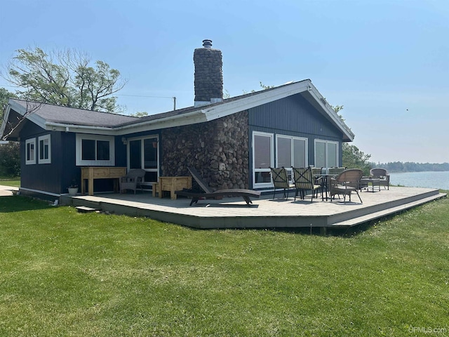 5847 County 513 T Rd, Rapid River, MI 49878 - rear view of house with a chimney, a deck with water view, a yard, and stone siding