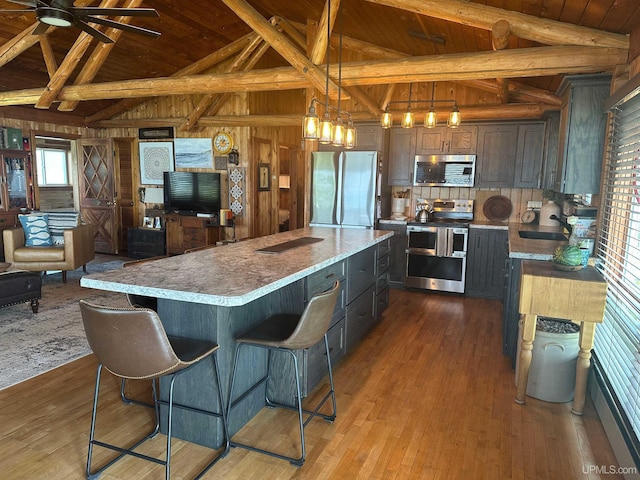 5847 County 513 T Rd, Rapid River, MI 49878 - kitchen featuring stainless steel appliances, wood ceiling, light countertops, a kitchen island, and wood walls