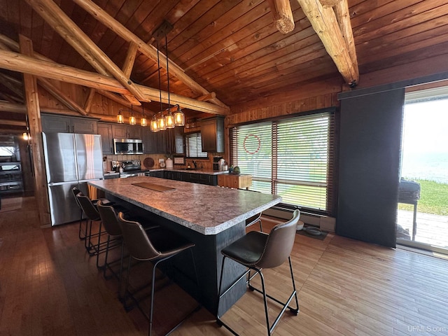 5847 County 513 T Rd, Rapid River, MI 49878 - kitchen with appliances with stainless steel finishes, wood ceiling, hardwood / wood-style floors, a breakfast bar area, and a center island
