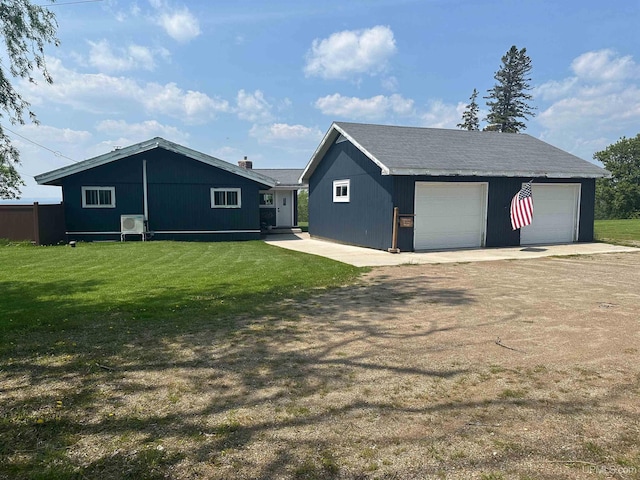 5847 County 513 T Rd, Rapid River, MI 49878 - view of side of home with a detached garage, an outdoor structure, and a yard