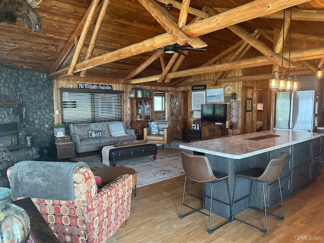 5847 County 513 T Rd, Rapid River, MI 49878 - kitchen featuring freestanding refrigerator, a wood ceiling with exposed beams, light wood-style flooring, wood walls, and a kitchen island