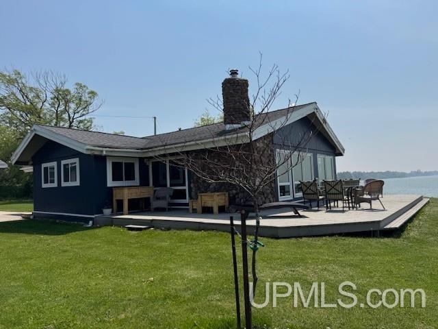5847 County 513 T Rd, Rapid River, MI 49878 - back of house with a yard, a deck with water view, and a chimney