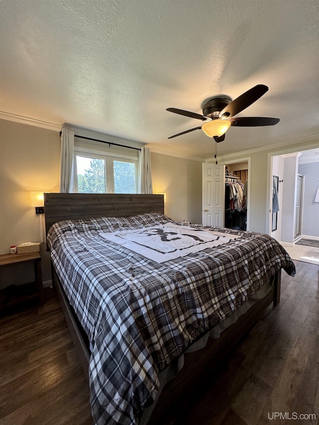 4828 I Rd, Bark River, MI 49807 - bedroom with ornamental molding, dark wood-type flooring, a spacious closet, a closet, and ceiling fan