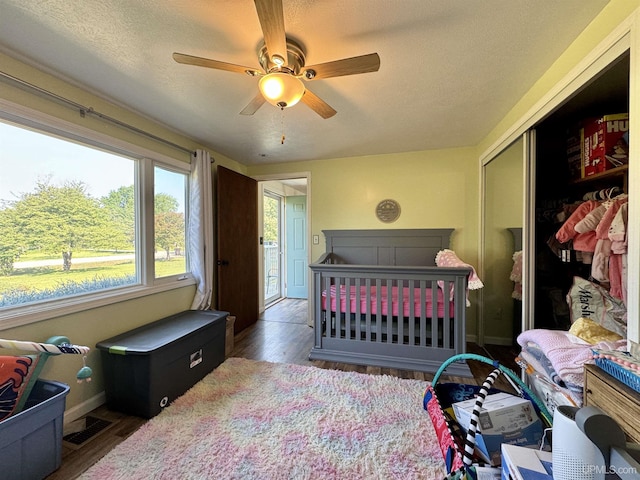 4828 I Rd, Bark River, MI 49807 - bedroom featuring wood finished floors, a closet, a textured ceiling, and a ceiling fan