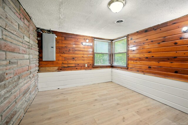 9970 Sedlock Ave, White Lake, MI 48386 - unfurnished room with a textured ceiling, electric panel, and wood finished floors