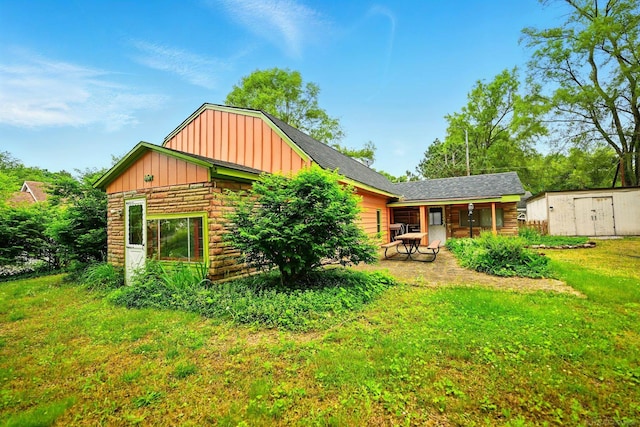 9970 Sedlock Ave, White Lake, MI 48386 - back of house featuring board and batten siding, a garage, a lawn, and stone siding