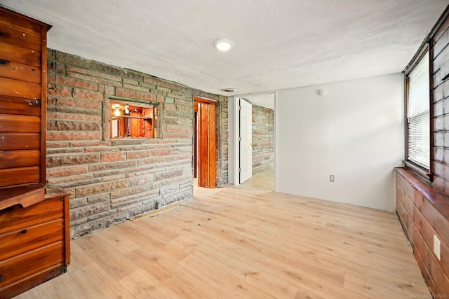 9970 Sedlock Ave, White Lake, MI 48386 - unfurnished room with brick wall, wood finished floors, and a textured ceiling