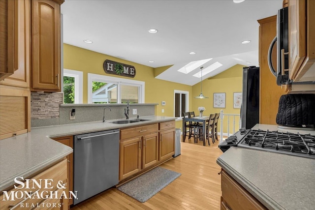 1076 Kelley St, Troy, MI 48083 - kitchen with stainless steel appliances, a skylight, tasteful backsplash, light wood-style flooring, and lofted ceiling
