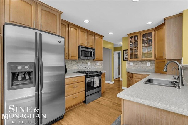 1076 Kelley St, Troy, MI 48083 - kitchen with stainless steel appliances, light wood-style flooring, glass insert cabinets, recessed lighting, and light countertops