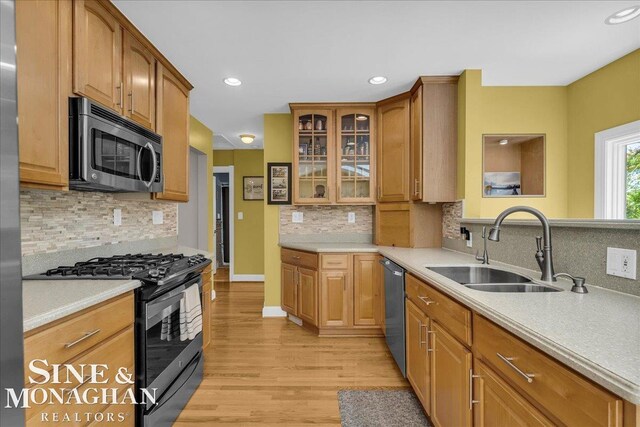 1076 Kelley St, Troy, MI 48083 - kitchen featuring appliances with stainless steel finishes, tasteful backsplash, light wood finished floors, glass insert cabinets, and light countertops