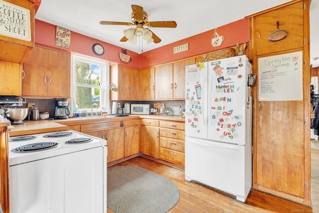 8941 Lakeshore Rd, Lexington, MI 48450 - kitchen with white appliances, decorative backsplash, light countertops, and a ceiling fan