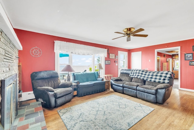 8941 Lakeshore Rd, Lexington, MI 48450 - living area featuring a stone fireplace, wood finished floors, ceiling fan, and ornamental molding