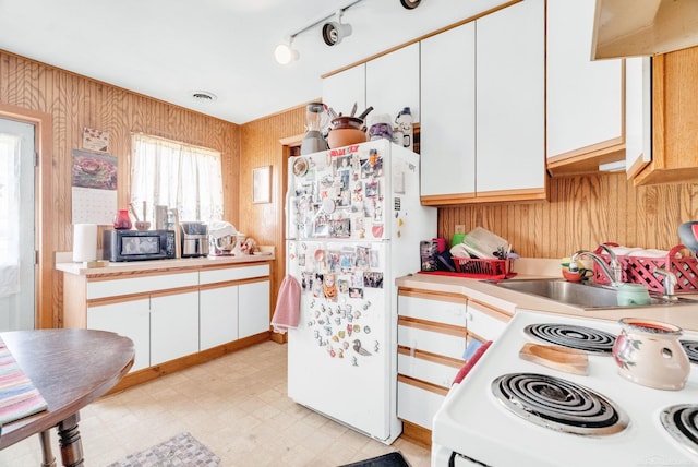 8941 Lakeshore Rd, Lexington, MI 48450 - kitchen with white appliances, light countertops, light flooring, white cabinetry, and wood walls