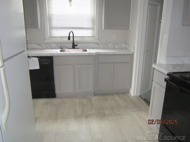 22636 Downing St, Saint Clair Shores, MI 48080 - kitchen with black appliances, light countertops, and white cabinets
