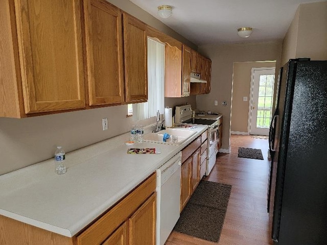 4161 Pine St, Gladwin, MI 48624 - kitchen with white appliances, wood finished floors, light countertops, and brown cabinetry