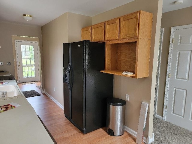 4161 Pine St, Gladwin, MI 48624 - kitchen with black fridge, light wood-style flooring, and light countertops