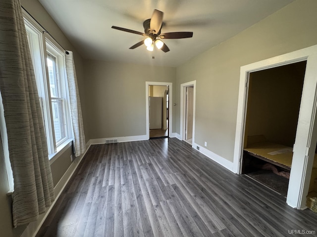 406 S 12th St, Escanaba, MI 49829 - unfurnished bedroom with dark wood-style flooring and a ceiling fan