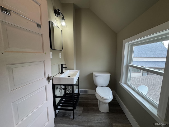 406 S 12th St, Escanaba, MI 49829 - half bath with wood finished floors, vaulted ceiling, and vanity