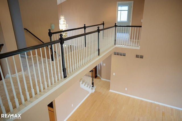 21832 Preserve Ct, Macomb Twp, MI 48042 - staircase featuring wood finished floors and a chandelier