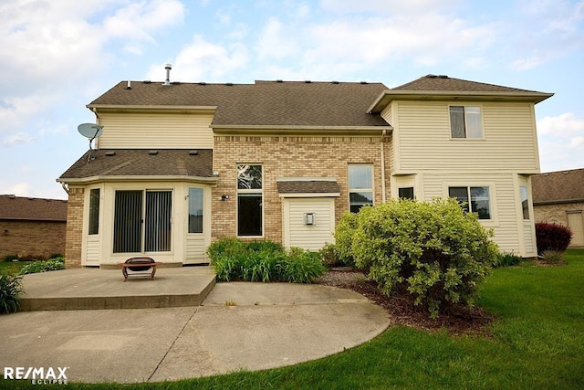 21832 Preserve Ct, Macomb Twp, MI 48042 - rear view of house with a patio, a fire pit, a lawn, roof with shingles, and brick siding