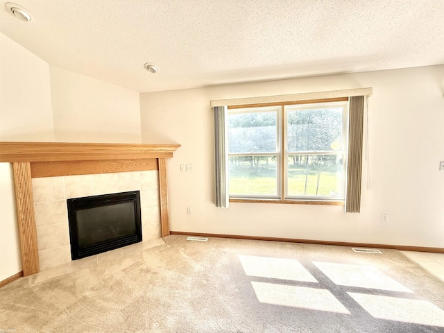 1248 S Hemlock Rd, Hemlock, MI 48626 - unfurnished living room featuring a textured ceiling, a tiled fireplace, and carpet flooring