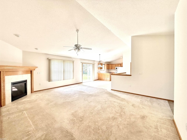 1248 S Hemlock Rd, Hemlock, MI 48626 - unfurnished living room featuring a textured ceiling, light colored carpet, ceiling fan, a tiled fireplace, and lofted ceiling