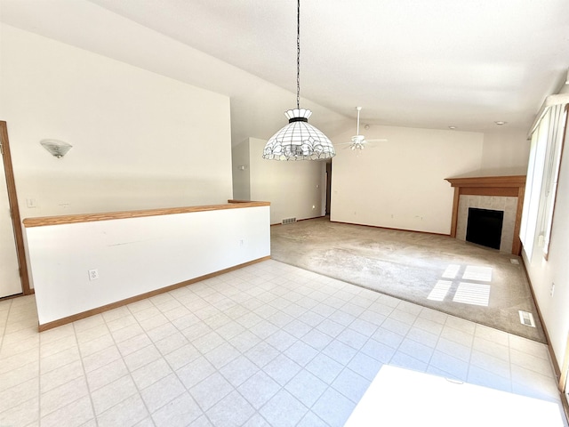 1248 S Hemlock Rd, Hemlock, MI 48626 - unfurnished dining area with lofted ceiling, ceiling fan, light carpet, a tiled fireplace, and light tile patterned flooring