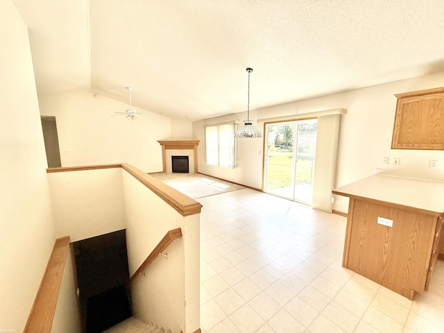 1248 S Hemlock Rd, Hemlock, MI 48626 - kitchen featuring a fireplace, open floor plan, a peninsula, light countertops, and light tile patterned floors