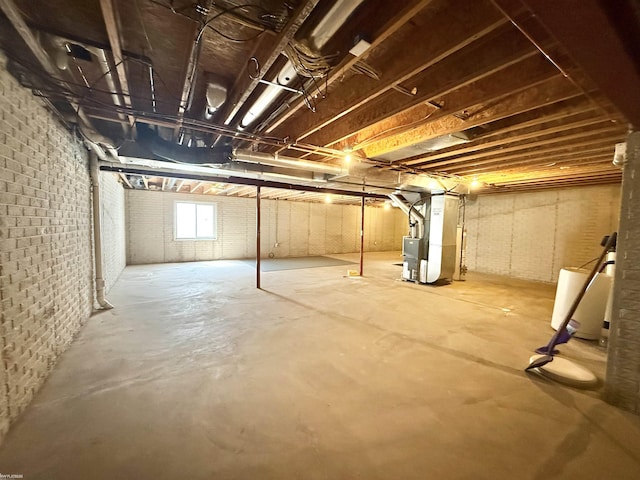 1248 S Hemlock Rd, Hemlock, MI 48626 - basement featuring heating unit and brick wall