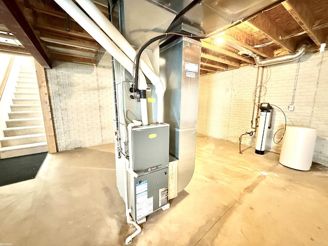 1248 S Hemlock Rd, Hemlock, MI 48626 - unfinished below grade area with brick wall, stairway, and heating unit