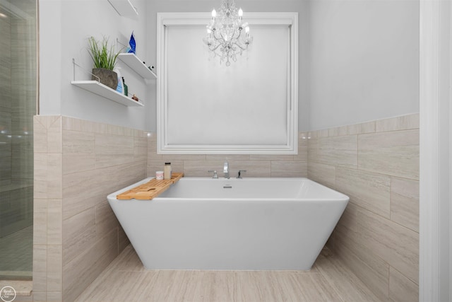 53081 Enclave Cir, Shelby Twp, MI 48315 - full bathroom featuring tile walls, a soaking tub, a chandelier, and wainscoting