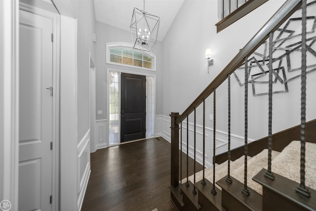 53081 Enclave Cir, Shelby Twp, MI 48315 - entrance foyer featuring a decorative wall, stairs, dark wood-style floors, a chandelier, and a wainscoted wall